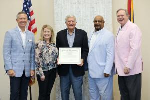 group photo of board with Ardillo holding certificate